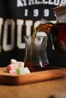 Pouring a Pitcher of Tea Into a Glass photo