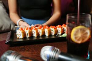 persona sentado a mesa con plato de Sushi foto