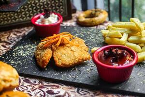 Tray of Fried Chicken and Fries on a Wooden Table photo