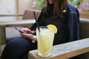 Woman Sitting on Bench With Lemonade and Cell Phone photo