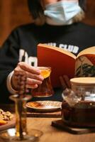 Person Wearing Face Mask Reading a Book Indoors photo