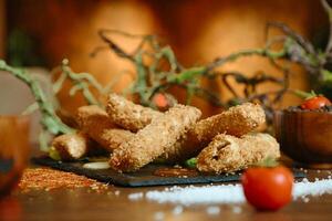 Table With Fried Food and Bowl of Tomatoes photo