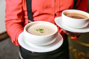 persona participación dos tazas de café en su manos foto