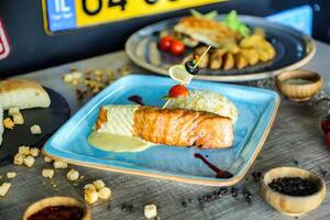 Blue Plate With Sauce-Covered Fish photo