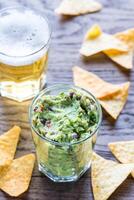 guacamole con tortilla papas fritas y vaso de cerveza foto