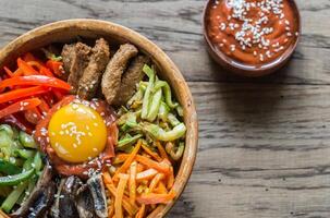 Bowl of bibimbap on the wooden table photo