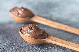 Two wooden spoons of chocolate cream photo