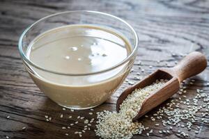 cuenco de tahini con sésamo semillas foto