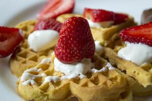 Ripe strawberry on waffles close up. Beautiful and tasty breakfast. photo