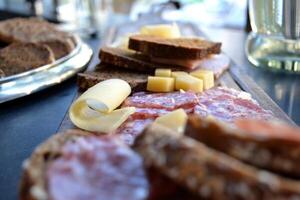 The sliced sausages and cheese on a kitchen table. photo