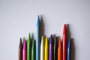 Multicolored pencils on white background. A palette of pencils on a table, close up. photo