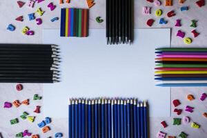 Multicolor letters and set of pencils on the table. Colorful wooden alphabet and pencils on a table. photo