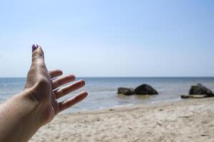 Girl's hand against seascape background. photo