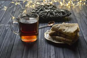 un taza de té y pasteles en un rústico mesa. acogedor invierno tiempo. foto