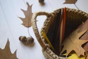 Autumn leaves in a basket on the desk. photo