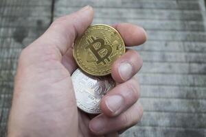 Golden and silver bitcoins on the wooden background. The coins of cryptocurrency. photo