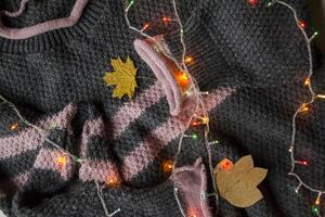 Women's sweater decorated with autumn leaves. Sweater texture. Cold season. photo