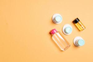 Set of travel size cosmetic bottles on colored background. Flat lay of cream jars. Top view of bodycare style concept photo