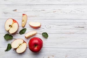 Fresh red apples with green leaves on wooden table. On wooden background. Top view free space for text photo