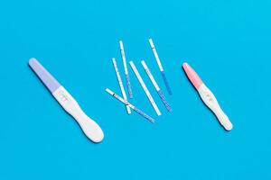 Colored Pregnancy test on colored background, top view with copy space photo