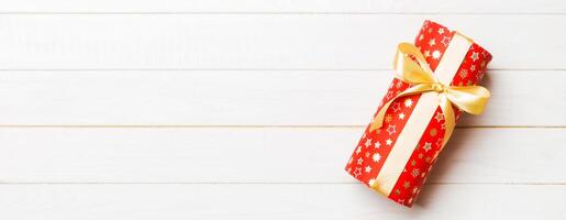 Top view of christmas or other holiday handmade present box package, flat lay white wooden background with copy space. new year gift box photo