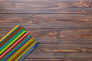 Heap of colorful plastic drinking straws on Colored background, flat lay. Copy Space for text photo