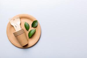 set of empty reusable disposable eco-friendly plates, cups, utensils on light white colored table background. top view. Biodegradable craft dishes. Recycling concept. Close-up photo