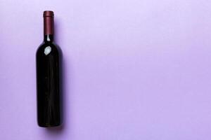 One Bottle of red wine on colored table. Flat lay, top view wth copy space photo