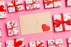 Top view of colorful valentine background made of craft envelope, gift boxes and red textile hearts. Valentine's Day concept photo