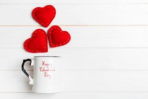 Top view composition of hearts splashing out from a cup on wooden background. Love and romance concept. Valentine's Day photo