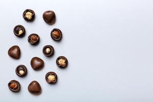 Different kinds of chocolates on colored table close-up. Top View and Flat Lay with copy space photo