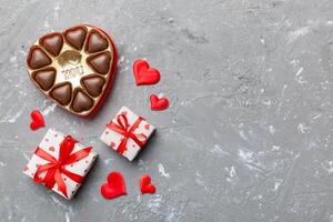 Delicious chocolate pralines in box for Valentine's Day. Heart shaped with gift box of chocolates top view with copy space photo