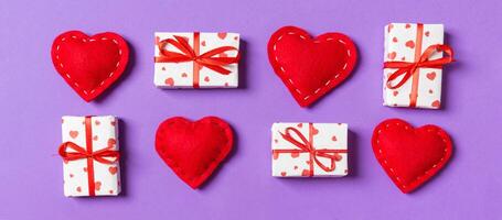 Top view of white gift boxes and red textile hearts on colorful background. Valentine's Day concept photo