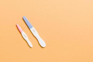 Colored Pregnancy test on colored background, top view with copy space photo