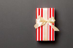 Top view Christmas present box with yellow bow on black background with copy space photo