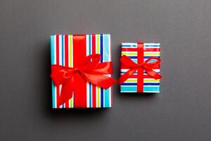 Gift box with red bow for Christmas or New Year day on black background, top view photo