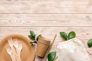 set of empty reusable disposable eco-friendly plates, cups, utensils on light white colored table background. top view. Biodegradable craft dishes. Recycling concept. Close-up photo