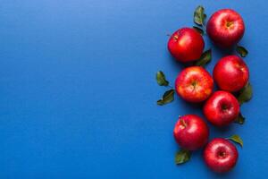 muchos rojo manzanas en de colores fondo, parte superior vista. otoño modelo con Fresco manzana encima ver con Copiar espacio para diseño o texto foto