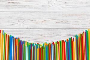 Heap of colorful plastic drinking straws on Colored background, flat lay. Copy Space for text photo