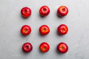 Many red apples on colored background, top view. Autumn pattern with fresh apple above view photo