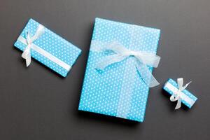 Gift box with white bow for Christmas or New Year day on black background, top view photo