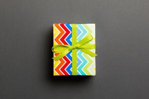 Top view Christmas present box with green bow on black background with copy space photo