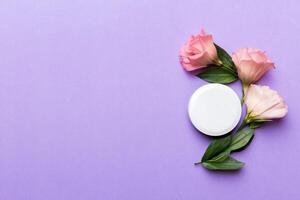 Composition with cosmetic products and beautiful roses on color background. Copy space, flat lay photo
