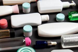 grupo de el plastico cuidado del cuerpo botella plano laico composición con cosmético productos en de colores antecedentes vacío espacio para usted diseño. conjunto de blanco cosmético contenedores, parte superior ver con Copiar espacio foto