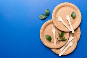 set of empty reusable disposable eco-friendly plates, cups, utensils on light white colored table background. top view. Biodegradable craft dishes. Recycling concept. Close-up photo