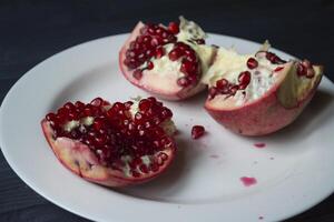 Pomegranate on a white plate. Close up. photo