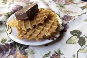 A waffles and chocolate candy on a saucer close up. photo