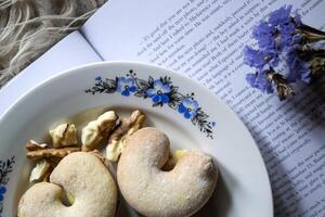 pastel y nueces en un plato en contra un libro antecedentes. cerca arriba. foto