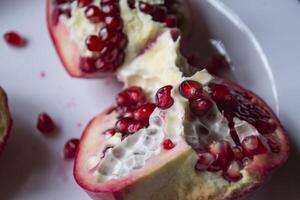 Pomegranate on a white plate. Close up. photo