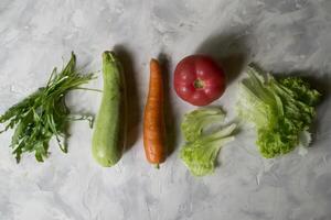 grupo de vegetales en un cocina mesa. ingredientes para Cocinando ensalada. foto